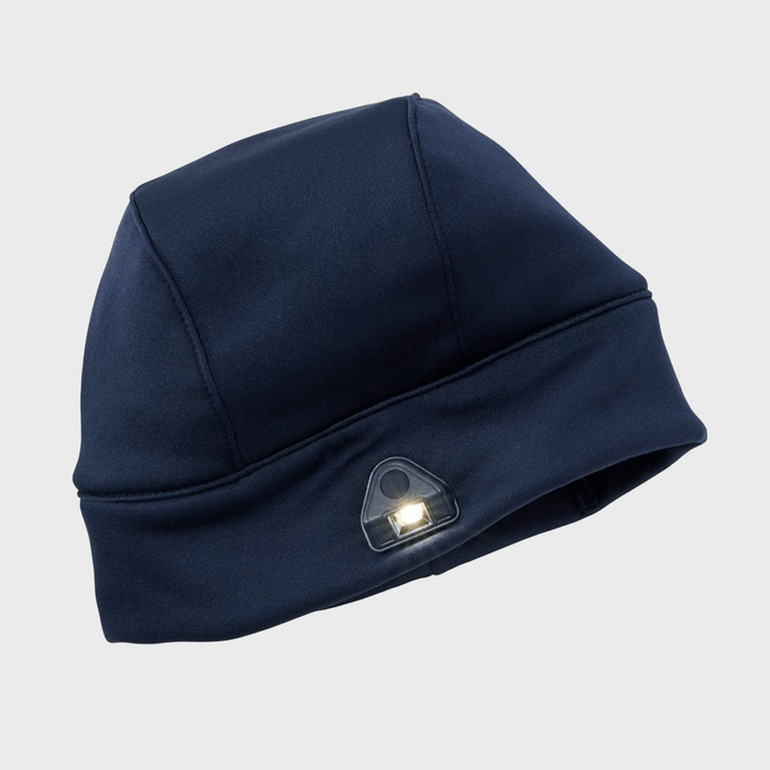 A navy blue beanie emits light from its built-in LED on the brim, set against a plain grey background.