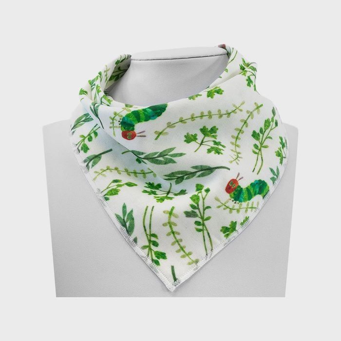 A baby bib displays colorful caterpillar and plant patterns, draped on a mannequin against a plain background.
