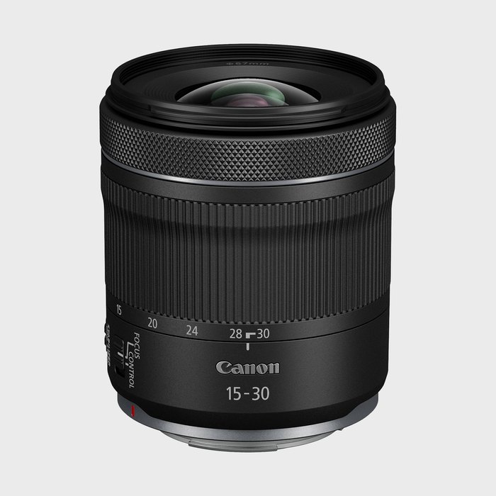 A black camera lens sits upright against a plain gray background, featuring 