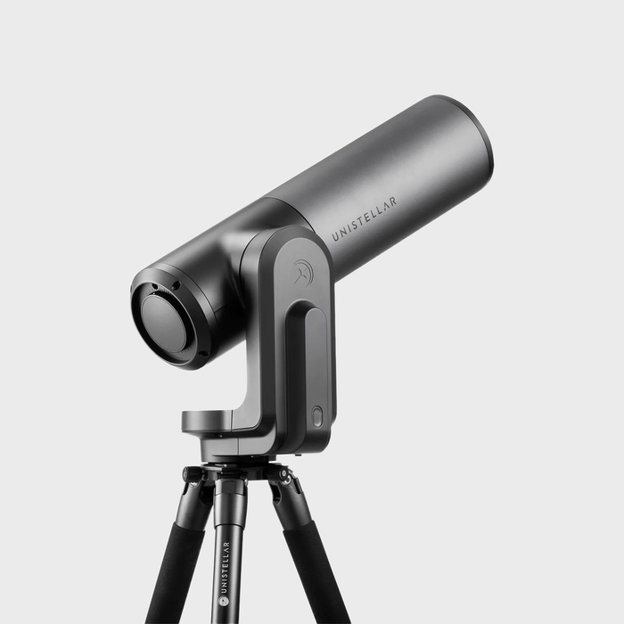 A sleek telescope rests mounted on a sturdy tripod, set against a plain background. 