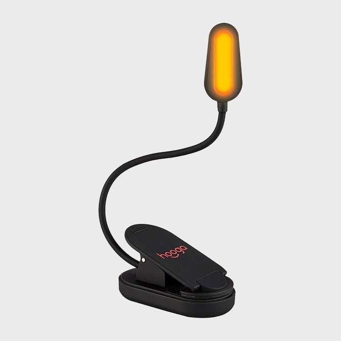 Lamp glowing, with flexible stem attached to clip base on plain background. 
