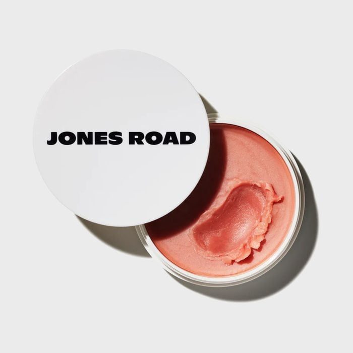 Container holds peach-colored balm with lid reading 