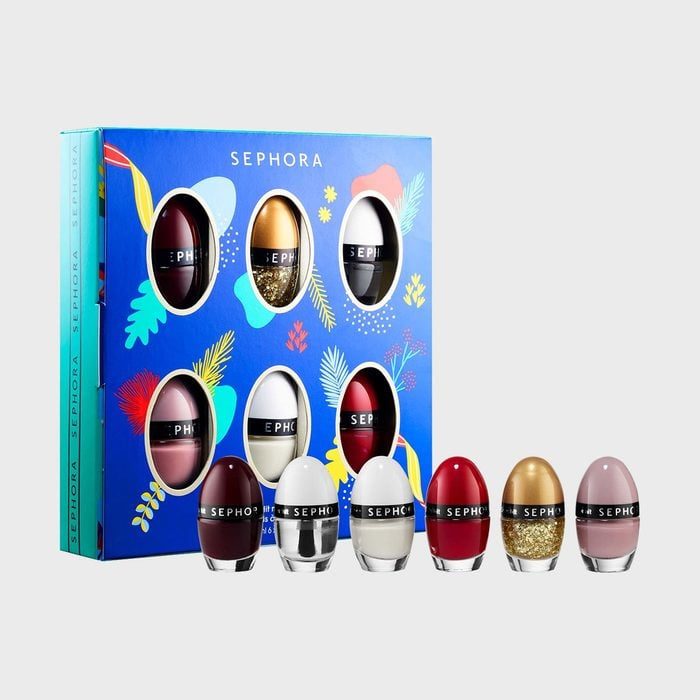 Sephora nail polish bottles displayed upright, showcasing a variety of colors. They are in front of a vibrant, decorated blue packaging set.