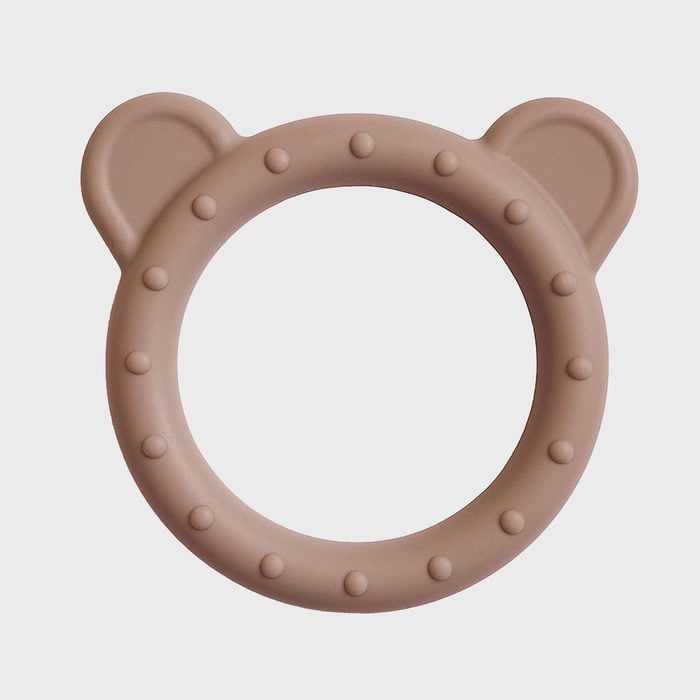 Brown silicone teething ring with bear ears rests against a plain, light background.