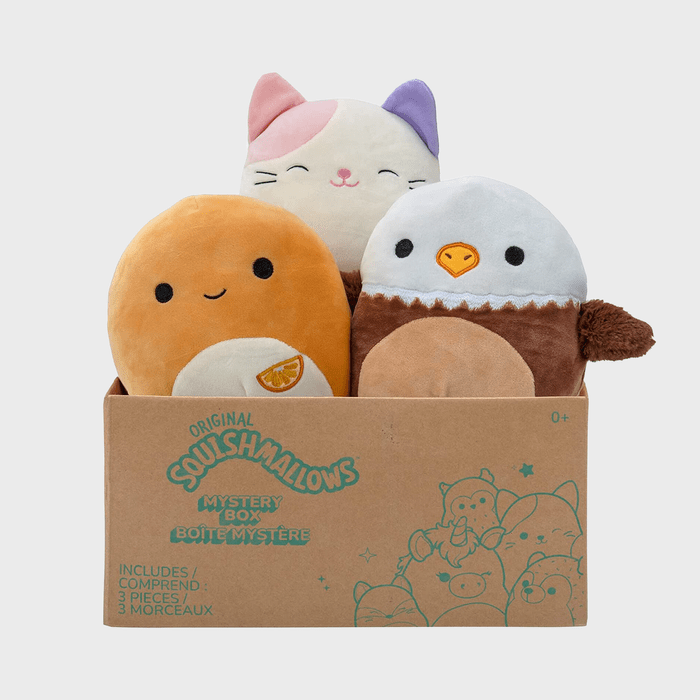 Three plush toys sit inside a brown box labeled 