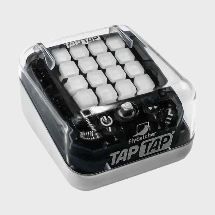 Small cube-shaped game device features 16 white buttons beneath a transparent cover, labeled 
