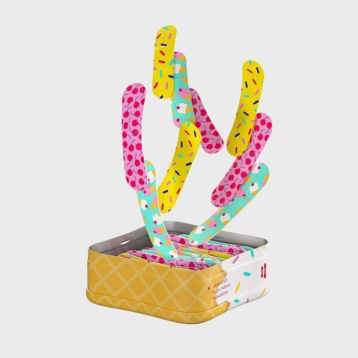 Colorful bandages sprout from a yellow, waffle-patterned tin, decorated with sprinkles and ice cream designs, creating a playful, abstract cactus shape.