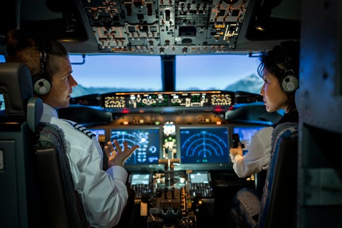Rear view of two pilots flying an commercial airplane jet