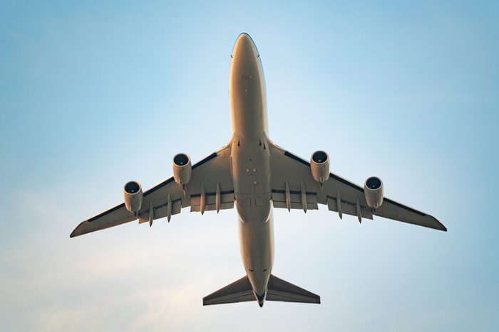Close-up commercial airplane flying in the sky from the bottom view