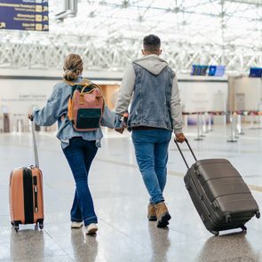 couple walking through airport with luggage