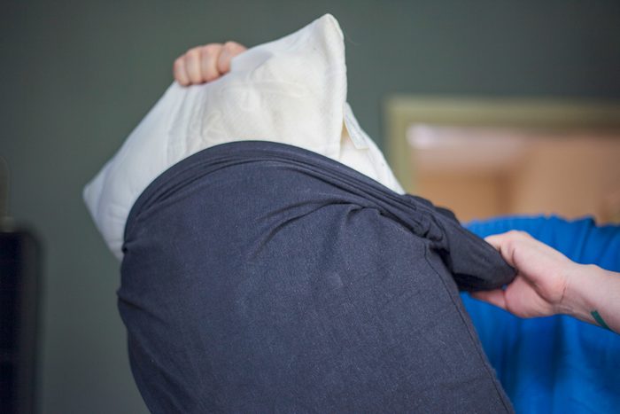 man removing pillow from pillowcase