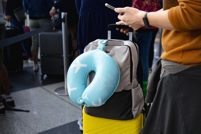 u shaped neck pillow with luggage at airport