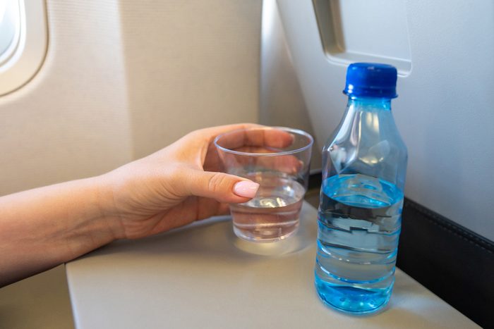water in a cup and bottle on flight