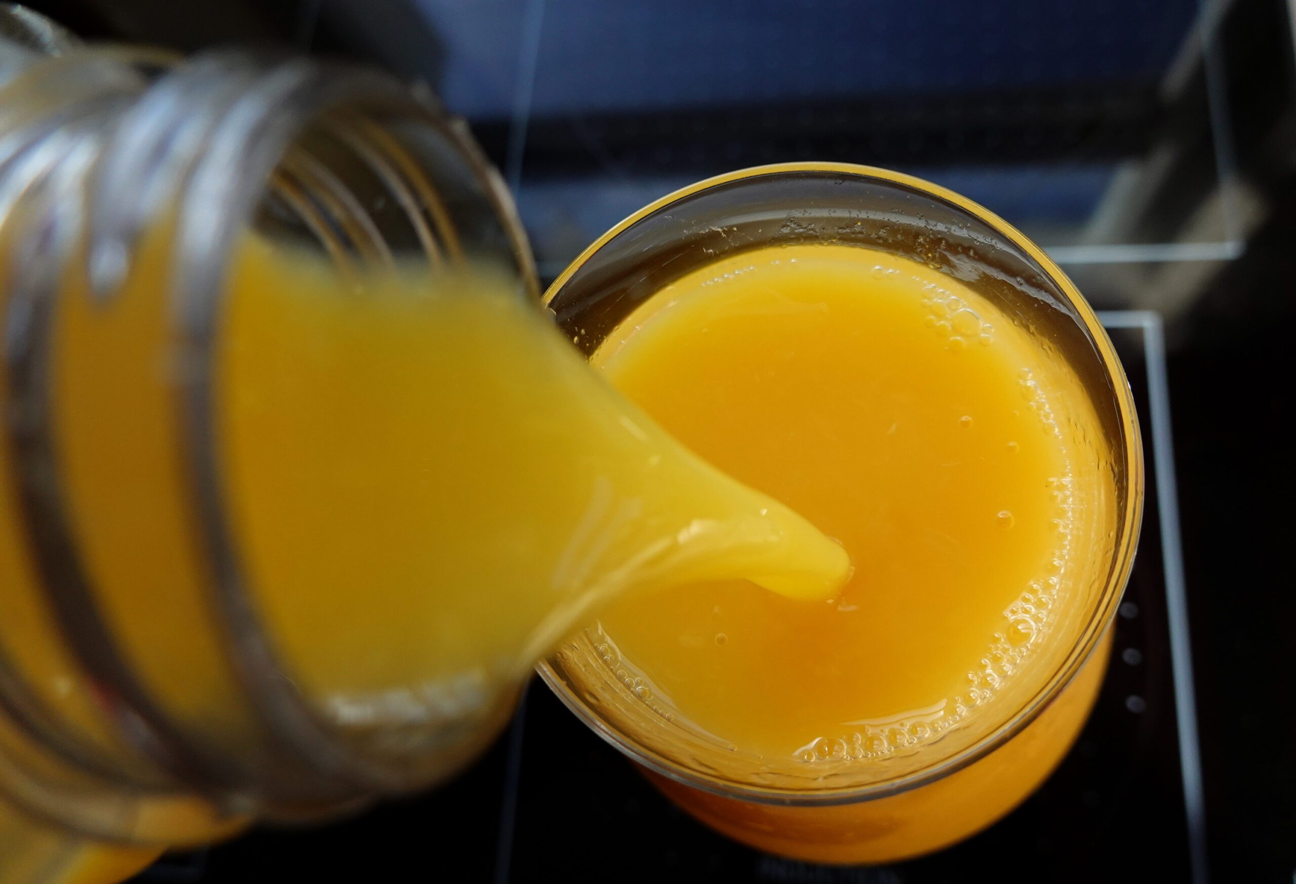 Orange juice being poured into a glass from above