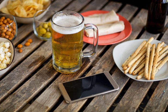 phone on a restaurant table with beer and food