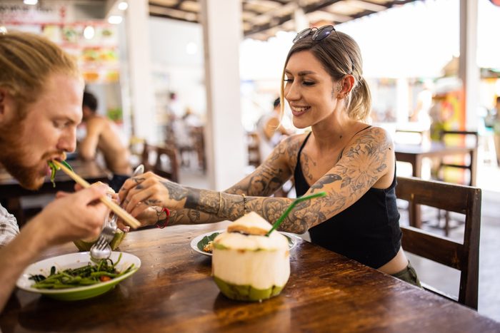 woman with tattoos eating at a restaurant