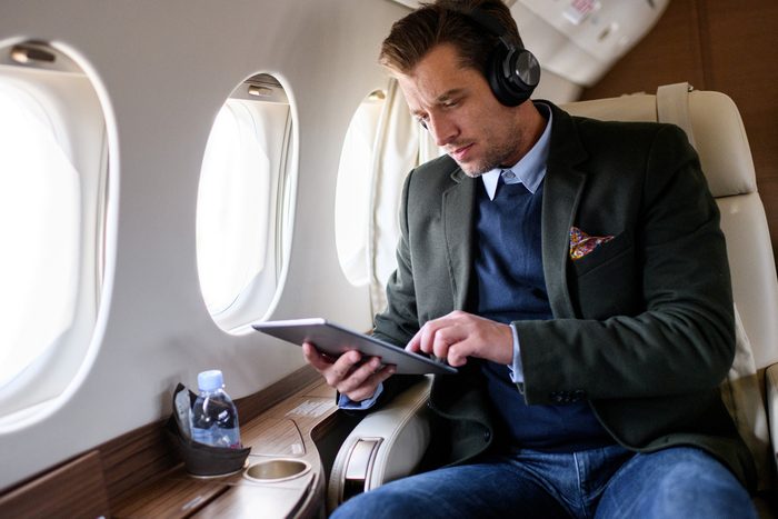 man using tablet on airplane
