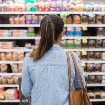 Woman stands in front of grocery store shelf