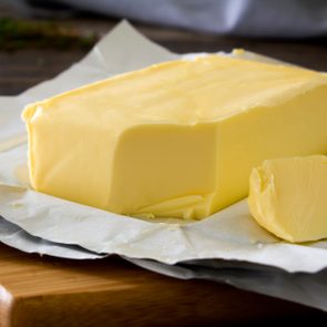 close up of block of butter on chopping board