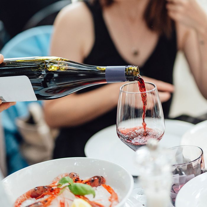 wine is being poured in a glass