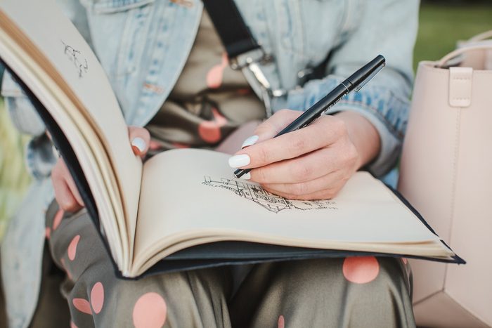 woman sketching with her left hand