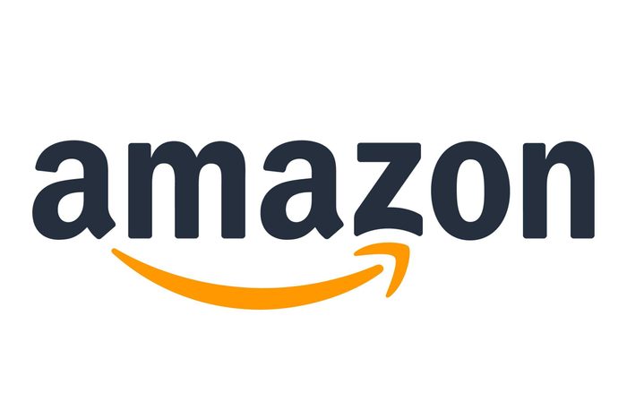 Package rests against a blue door on a concrete step, featuring distinctive Amazon Prime branding and barcodes.