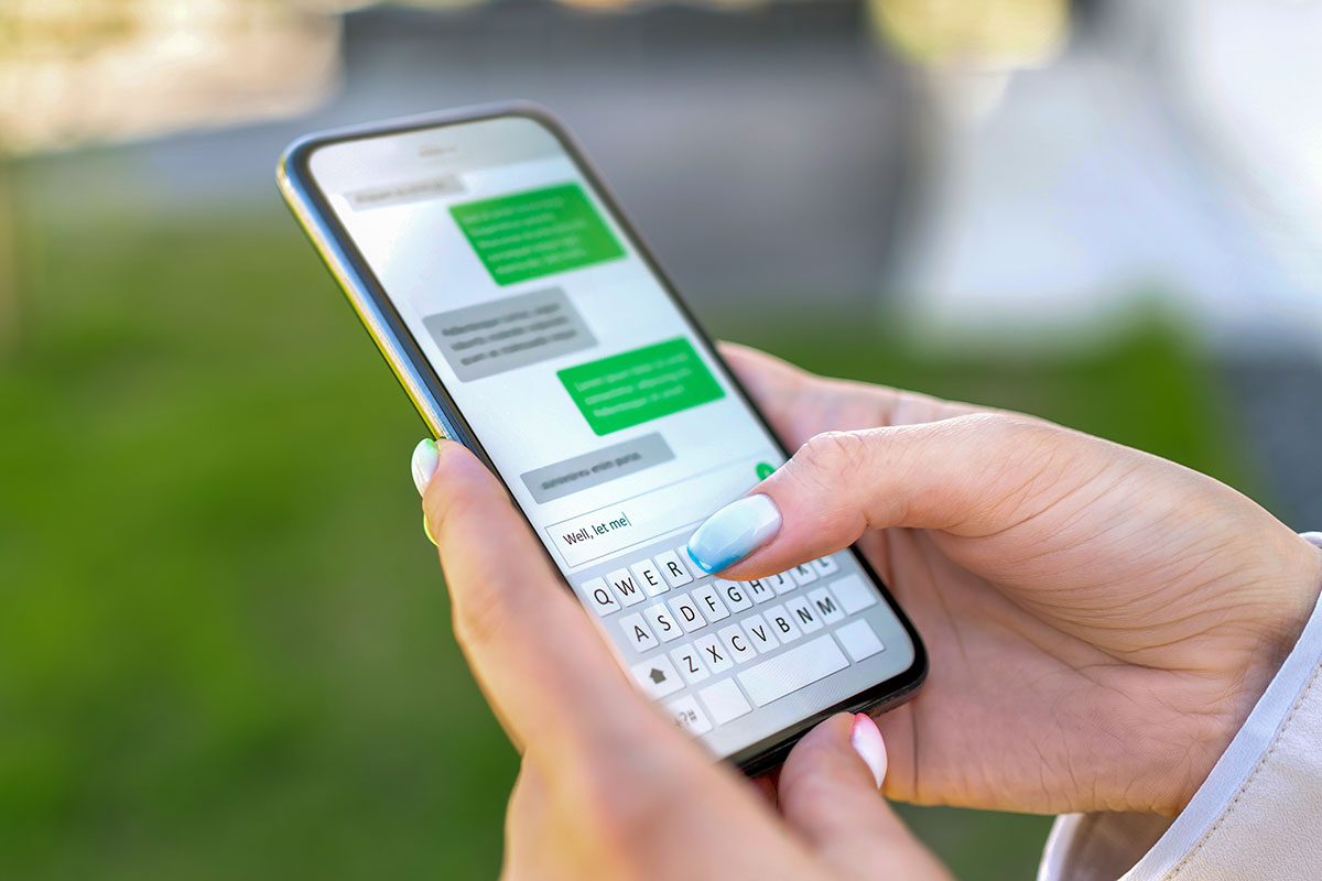 Woman sending text message with cellphone.