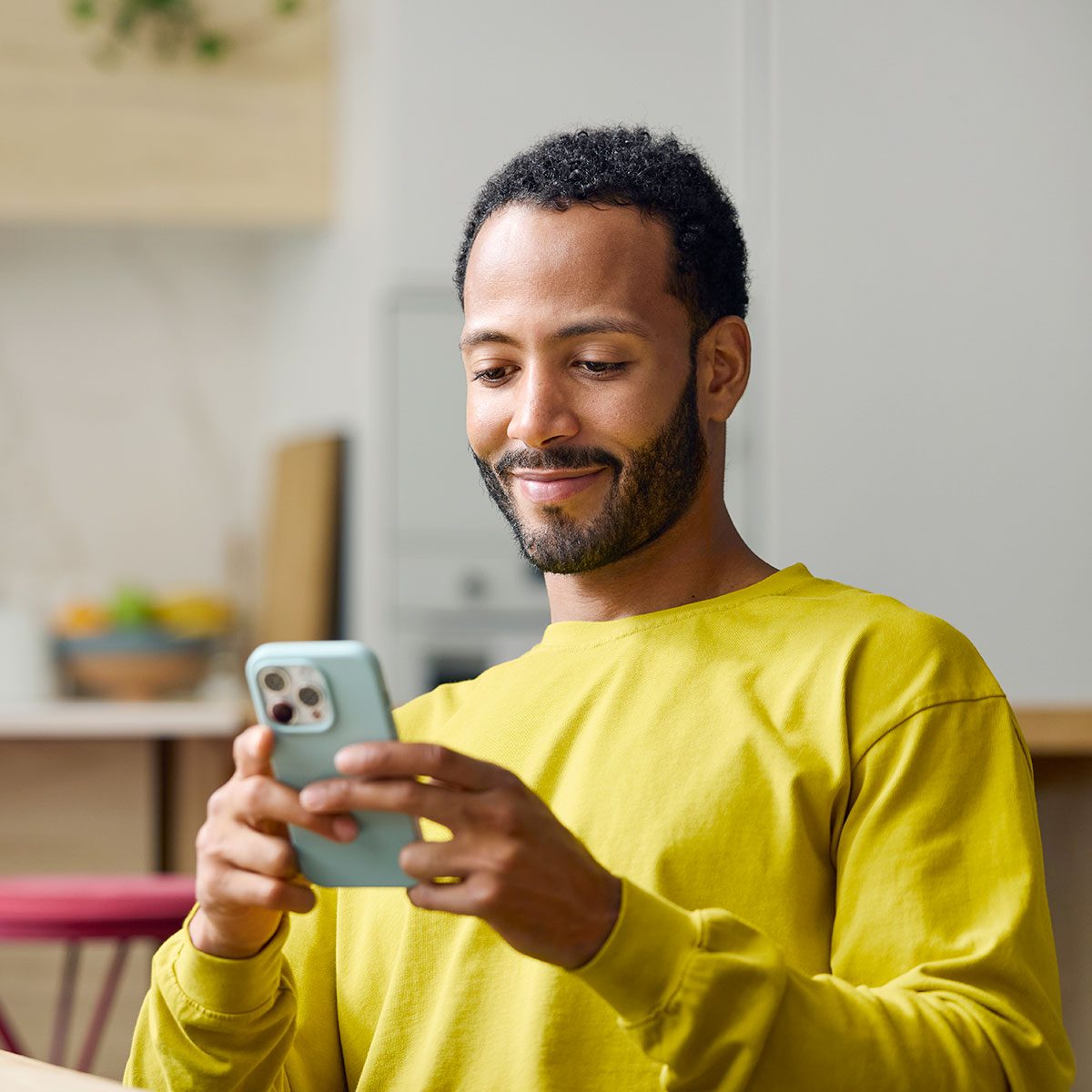 Smiling young man using smart phone.
