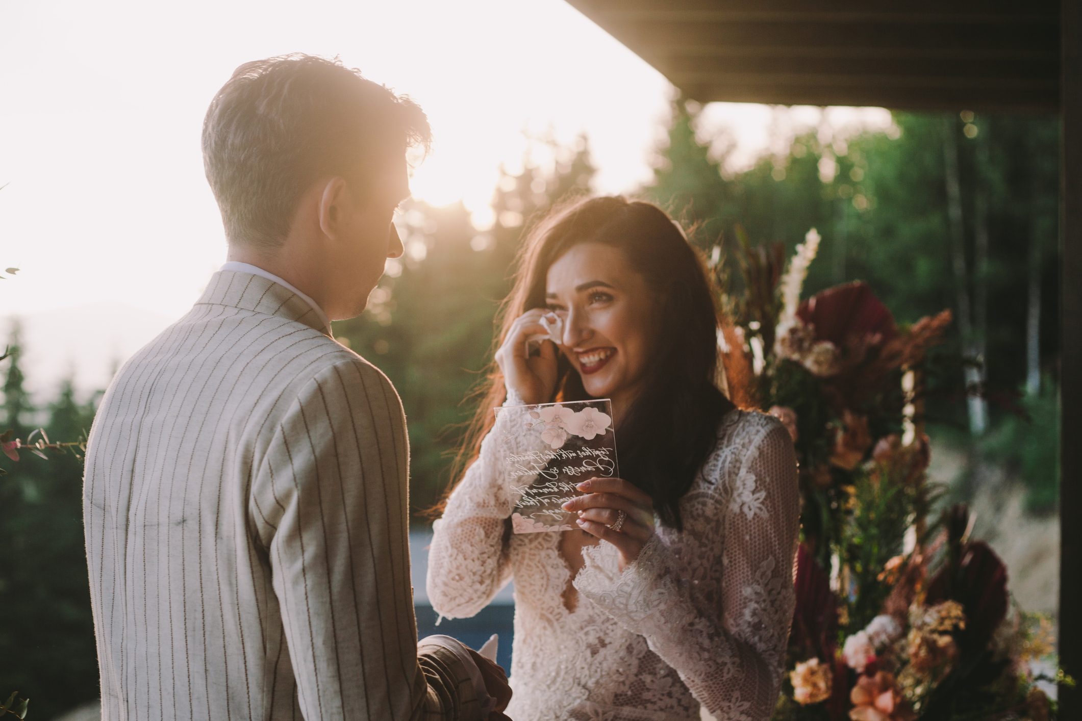 Bride crying while reading vows during a wedding at sunset
