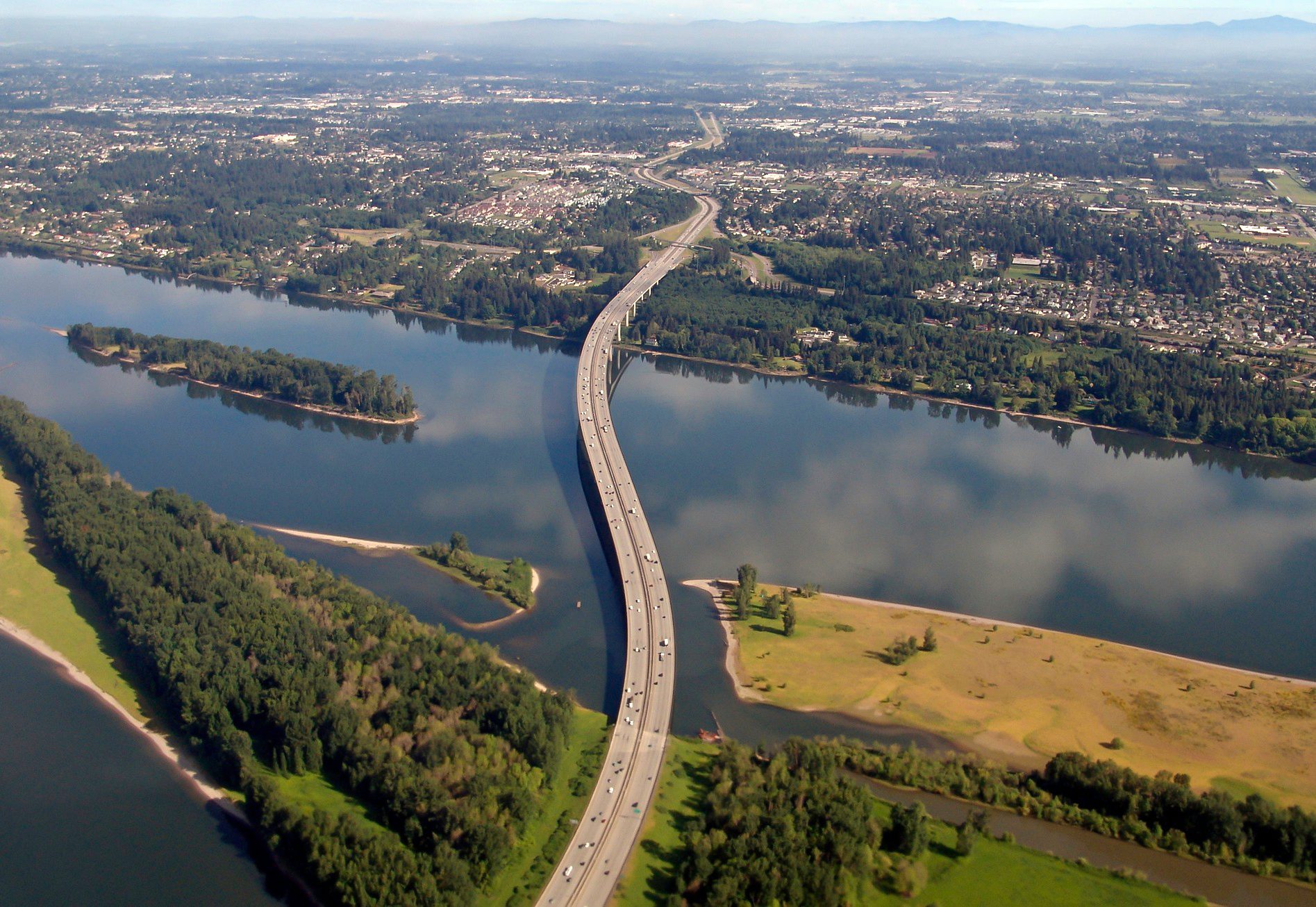 Bridge over a river heading into a city, aerial view
