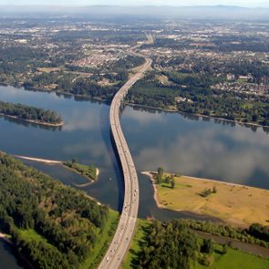 Bridge over a river heading into a city, aerial view
