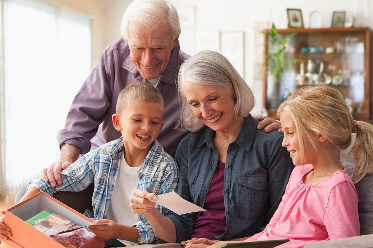 couple looking at photographs with grandchildren
