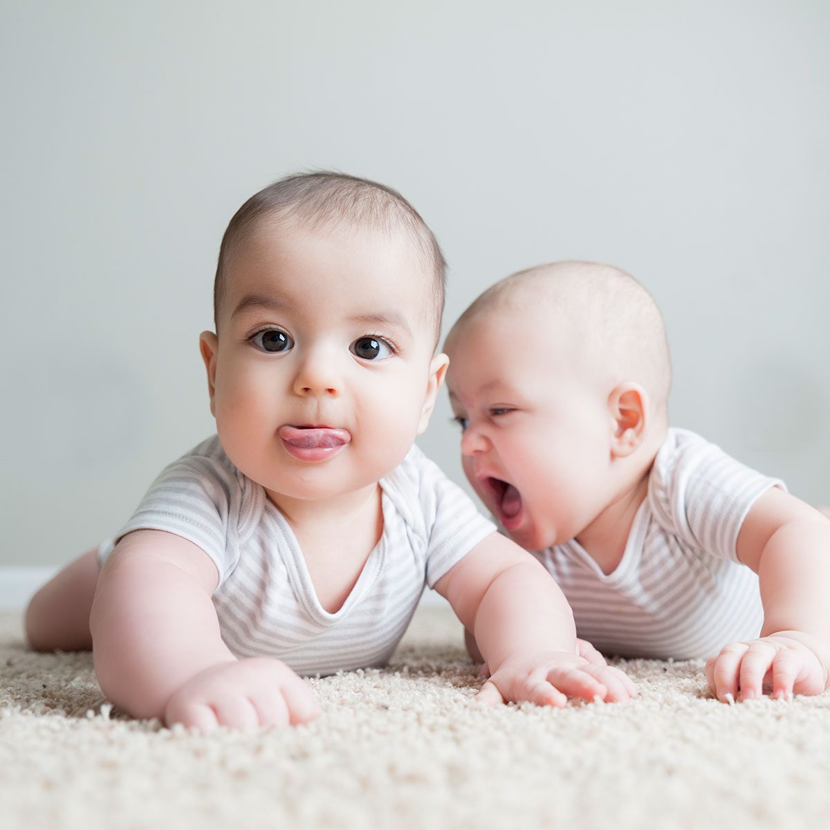 Fraternal twin boys cheerfully play with each other