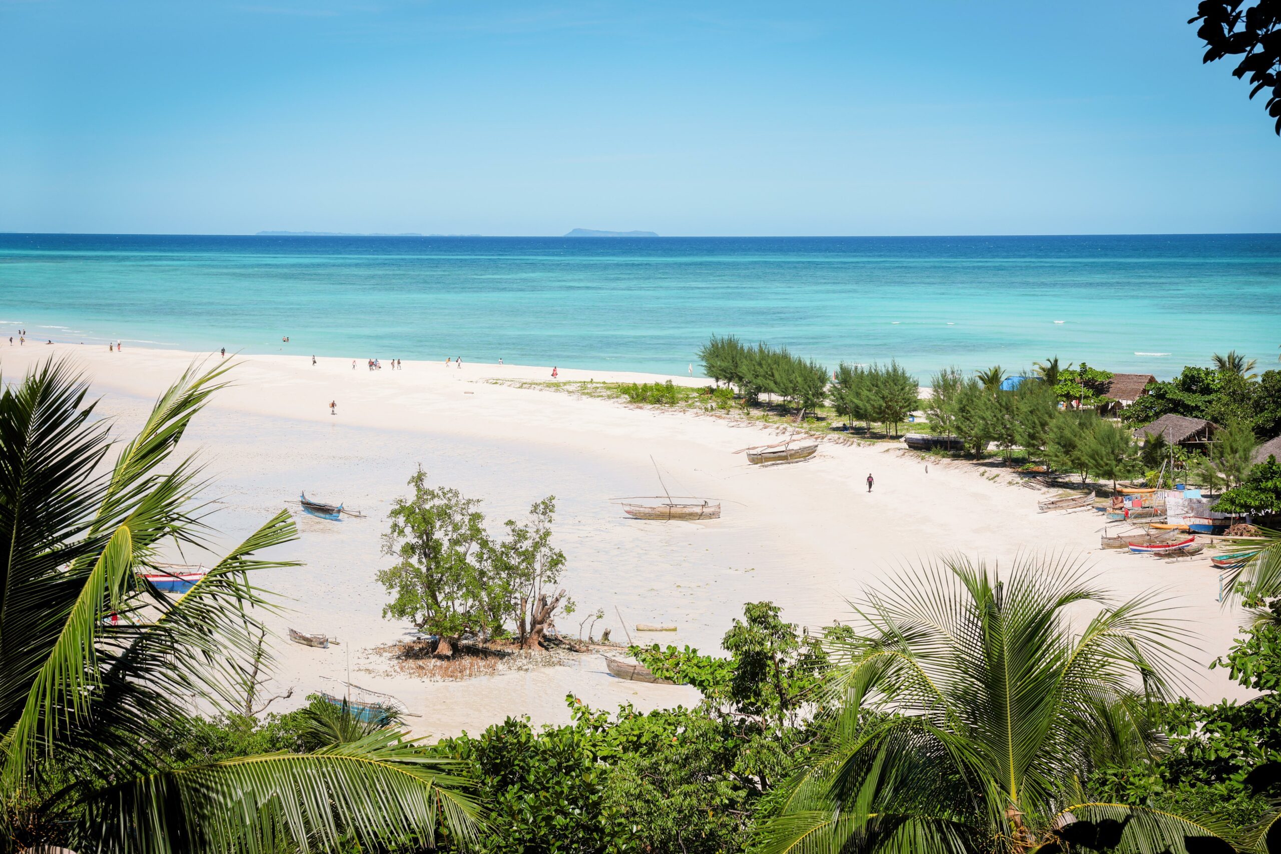 White sandy beaches meet the turquoise waters of Nosy Iranja Island, featuring lush greenery and a peaceful atmosphere perfect for relaxation and exploration.
