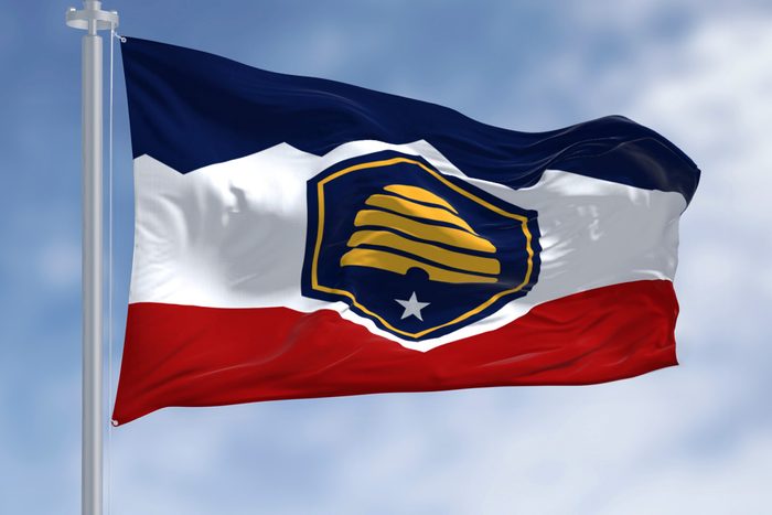 Utah state flag waving on a clear day